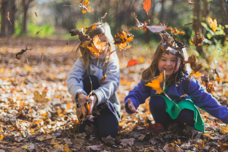 Kinder_spielen_mit_Laub