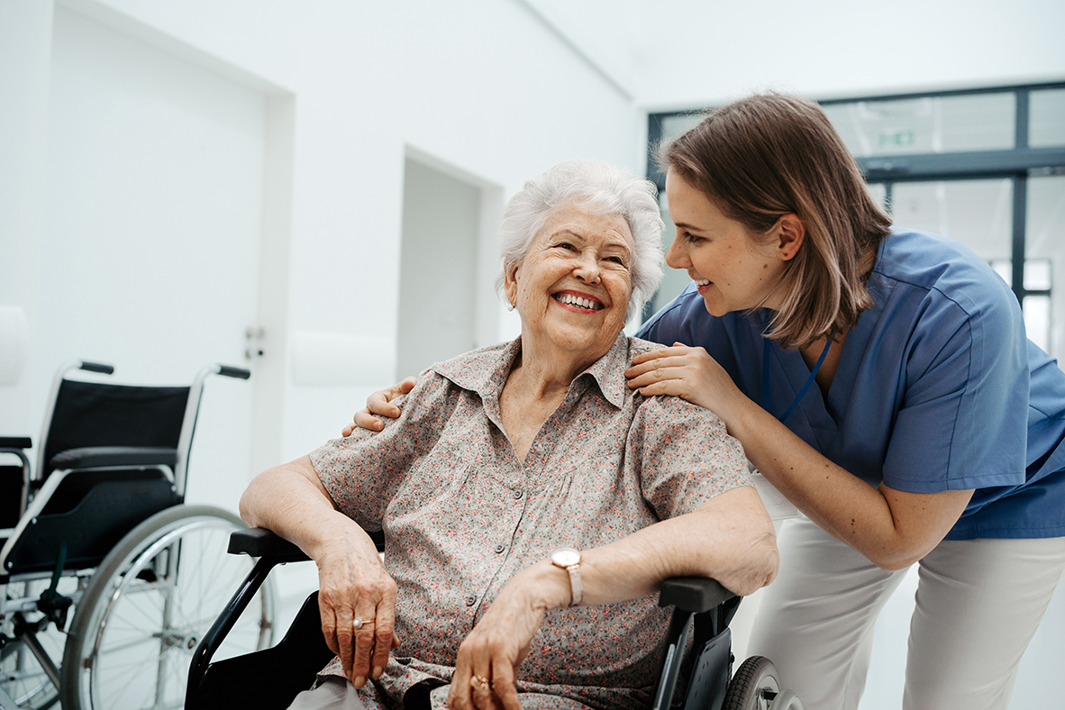 Portrait of nurse and senior patient talking in hospital corridor. Emotional support for elderly woman.